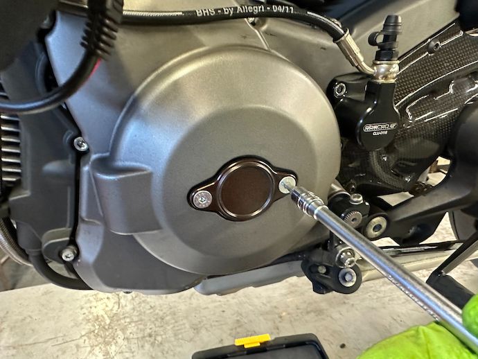 Unscrewing flathead screws holding on crankshaft access cover